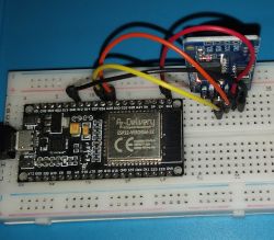 ESP32 board with connected sensor module on breadboard using colored wires