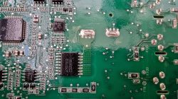 Zbliżenie płyty układu scalonego z elementami elektronicznymi i oznaczeniami.