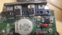 Zbliżenie na płytkę drukowaną z widocznymi komponentami elektronicznymi, w tym tranzystorami TIP127 i TIP27.
