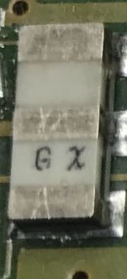 Close-up of an SMD component with GX marking on a circuit board.