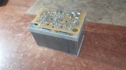 Electronic circuit on an aluminum heatsink on a desk.