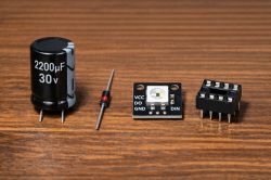 2200µF 30V capacitor, Zener diode, WS2812B module, and DIP8 socket on wooden table