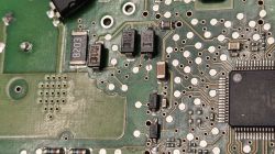 Zbliżenie na płytę PCB z elementami SMD, w tym oznaczenia US1J i 8203