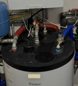 Vaillant cylinder with a black top cover and connected pipes with red and blue insulation