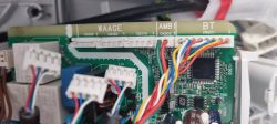 Close-up of a printed circuit board in an electronic device with colored wires connected to connectors.