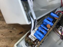 Wnętrze starego głośnika komputerowego z elementami elektronicznymi.
