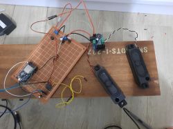 Układ elektroniczny z ESP32, modułem RDA5807M, wzmacniaczem TDA7266 i głośnikami na płytce prototypowej.
