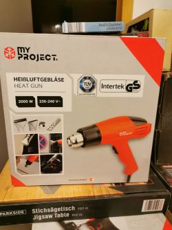 Opakowanie opalarki „My Project” o mocy 2000W w kolorze czerwonym, ustawione na innym pudełku.