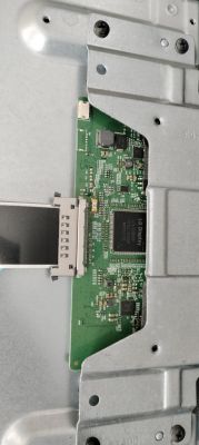 Printed circuit board with chips and a flat ribbon cable mounted on a metal housing.