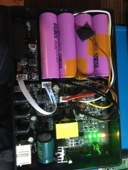 Open electronic device showing batteries and circuit board.