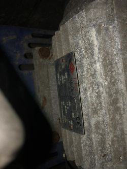 Tabliczka znamionowa silnika elektrycznego zamontowanego na sprężarce.
