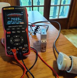 ANENG AOS02 electrical meter and TONGOU relay on a wooden table.