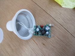 Electronic Circuit and LED Bulb Housing Electronic circuit and LED bulb housing on a wooden background.