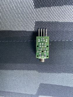 Zielona płytka PCB z wyjściem AUX i czterema pinami.