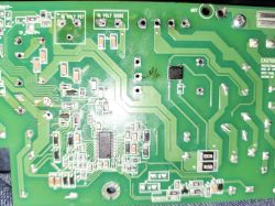 Printed circuit board with surface-mounted components and labeling Green PCB with visible traces, SMD components, and mounting holes