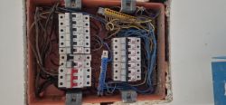 Rozdzielnica elektryczna z dużą liczbą przewodów i wyłączników nadprądowych w domku jednorodzinnym.