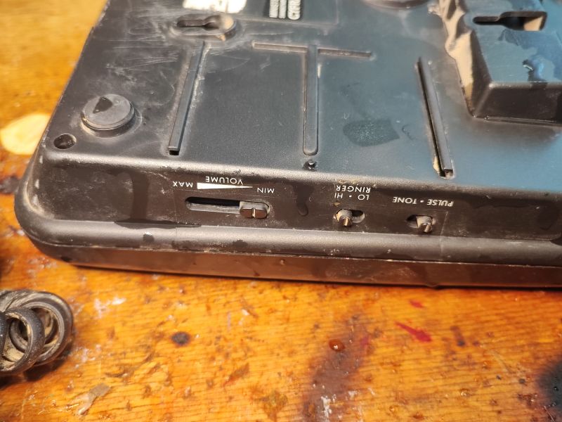 Regulacja głośności i przełączniki na spodzie telefonu Proton T1332.
