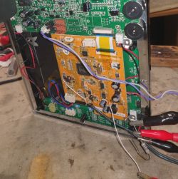 Wnętrze obudowy elektronicznej z widocznymi płytkami drukowanymi i podłączonymi przewodami.