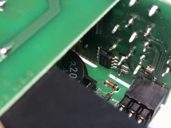 Zbliżenie na płytkę drukowaną z widocznymi elementami elektronicznymi i połączeniami lutowanymi.