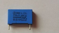 Niebieski kondensator CBB62 z oznaczeniami parametrów 0,056 uF, 275V AC.