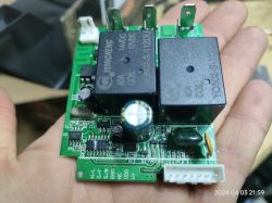 Płytka PCB trzymana w ręce, zawierająca różne elementy elektroniczne, w tym przekaźniki marki YONGCHENG.