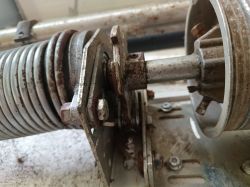 Mechanizm bramy garażowej z widocznymi sprężynami i zębatkami.