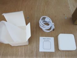 Zigbee gateway starter kit contents on a wooden table.