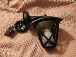 Czarna lampa najazdowa z wymienioną diodą na tle tekstylnego materiału.