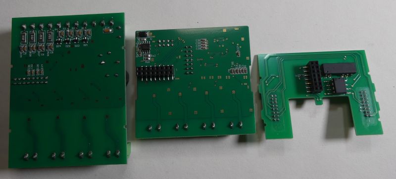 Trzy zielone płytki drukowane PCB z elementami elektronicznymi i złączami, ułożone na jasnym tle.