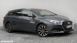 A dark gray Hyundai i40 car parked on a gravel surface.