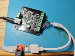 Electronic module with connected wires and 12V LED strip on blue mat