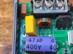 Zbliżenie płytki PCB z dławikiem toroidalnym, kondensatorem 47 µF 400 V i elementami wejścia zasilania