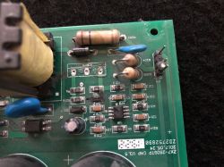 Zdjęcie uszkodzonego modułu elektronicznego na zielonej płytce PCB.