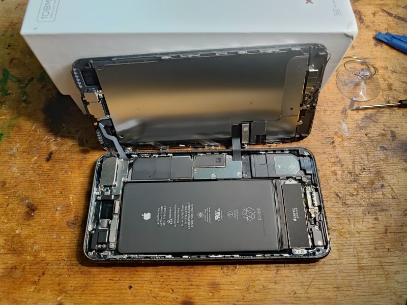 iPhone Interior During Battery Replacement Open interior of an iPhone showing components, including the battery and screen.