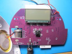 Printed circuit board with an LCD display and other electronic components.