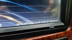 Close-up of a car radio screen showing MCU: M4-LED-SUB-CAR-BT-IR12-V1.