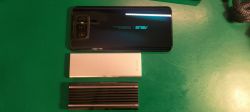Smartfon Asus oraz dwie obudowy na zielonym tle.