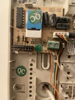 Zbliżenie na wnętrze unifonu Fermax 3594 z widocznymi elementami elektronicznymi i przewodami.
