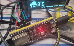 ESP module connected to an OLED display with a weather message.