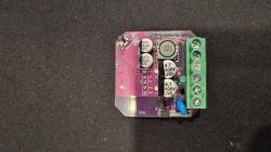 PCB with capacitors, coil, and screw terminals on a black background