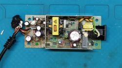 Widok zasilacza impulsowego z różnymi komponentami elektronicznymi, w tym rezystorami i tyrystorem.