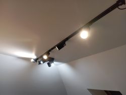 Czarny zestaw szynowy LED zamontowany na suficie, wszystkie lampki świecą przy różnych kątach.
