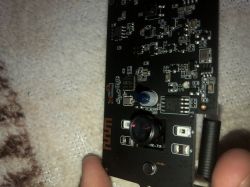 Close-up of a black PCB with a camera lens, LED diodes, and a DC power jack on the right