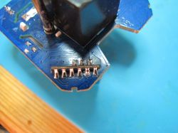 Close-up of Soldered Pins on PCB Close-up of soldered pins on a blue PCB.