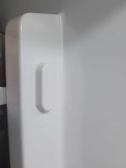 Wnętrze lodówki z widocznym żółtym przebarwieniem na ścianie.