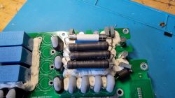 Wnętrze rozebranej ładowarki samochodu elektrycznego z widocznymi elementami elektronicznymi.