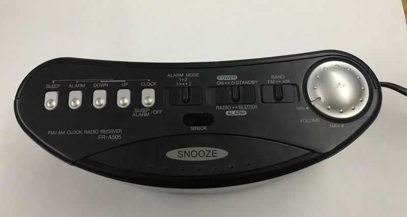 Widok z góry panelu sterującego radiobudzika FR-A505 z przyciskami i pokrętłem.