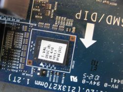 Zbliżenie płyty PCB z układem scalonym w ramce i białą strzałką na laminacie