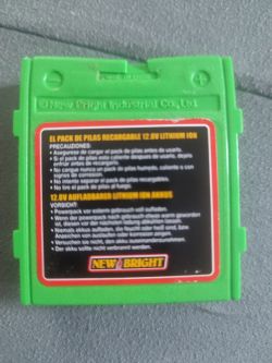 Zielony akumulator litowo-jonowy 12,8V marki New Bright z instrukcjami bezpieczeństwa.