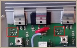 Zbliżenie na płytkę elektroniczną z zaznaczonymi polami zawierającymi elementy SMD.